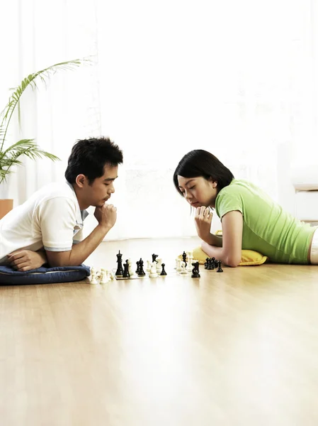 Casal jogando xadrez no chão — Fotografia de Stock