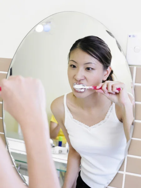 Dişlerini fırçalayan genç bir kadın — Stok fotoğraf