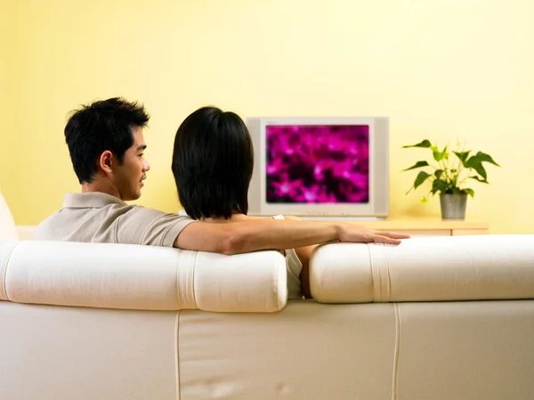 Casal assistindo televisão na sala de estar — Fotografia de Stock