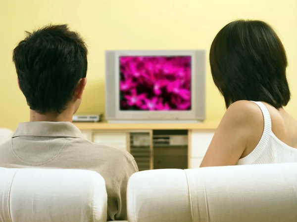 Giovane coppia guardando la televisione in soggiorno — Foto Stock