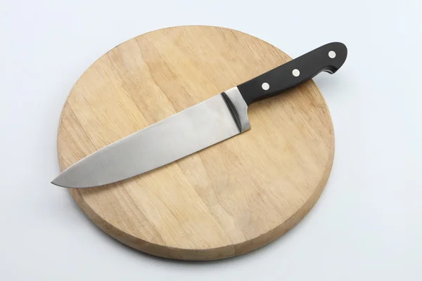 Düz renkli arka plan üzerinde kesme tahtası üzerinde bıçak — Stok fotoğraf