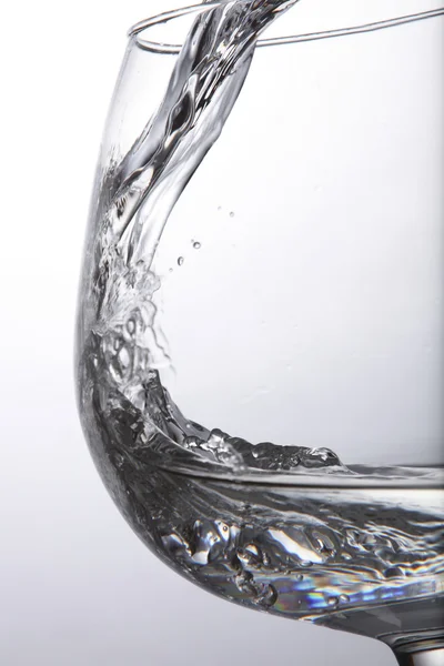 Wasser in den Behälter mit weißem Hintergrund gießen — Stockfoto