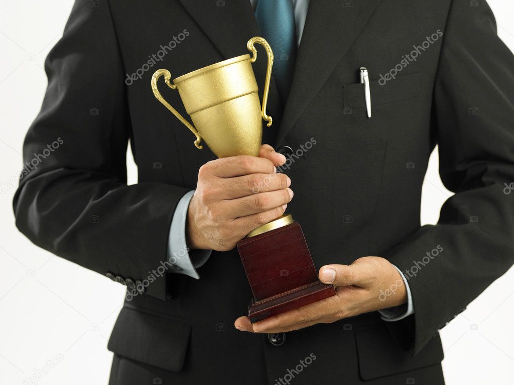 A winner with suit holding a throphy