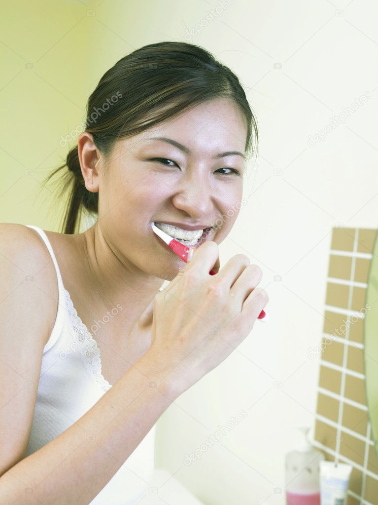 A young woman brushing teeth