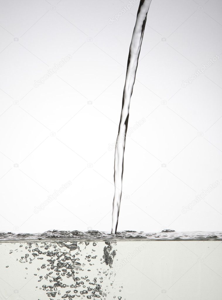 Pouring water to the container with white background