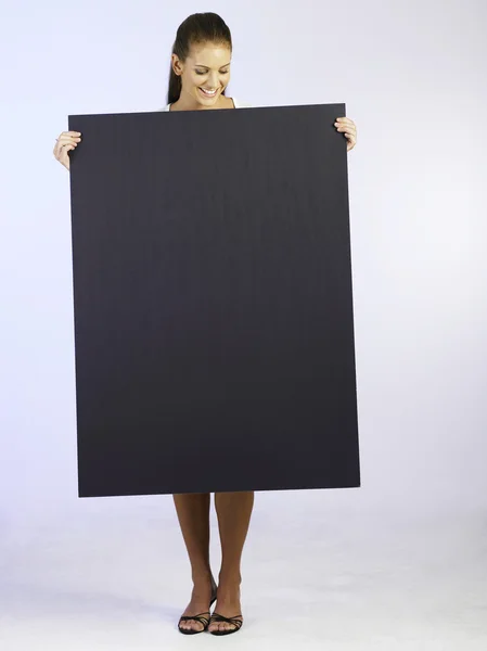 Mulher segurando cartão de tamanho grande — Fotografia de Stock