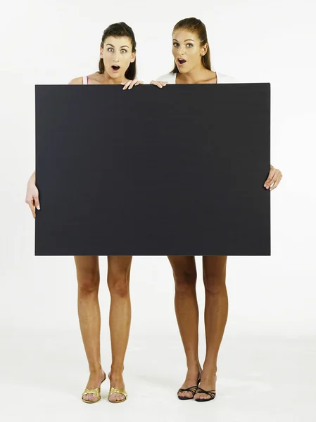 Duas mulheres segurando cartão — Fotografia de Stock
