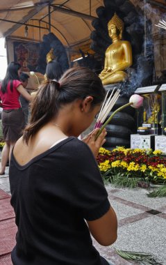 Tayland, bangkok, chinatown district, yaowarat road, traimitwitthayaram Tapınağı (wat traimit), bir Taylandlı kız dua Buda heykelleri önünde