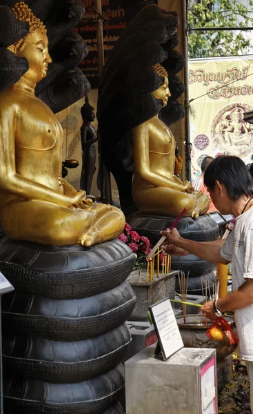 Tailandia, Bangkok, Chinatown District, Yaowarat Road, Traimitwitthayaram Temple (Wat Traimit), un hombre tailandés ofrece palos religiosos quemados a estatuas de Buda —  Fotos de Stock