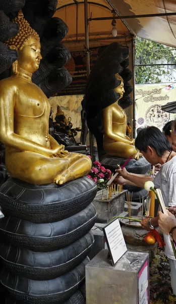 Thailandia, Bangkok, Chinatown District, Yaowarat Road, Traimitwitthayaram Temple (Wat Traimit), un uomo thailandese offre bastoni ardenti religiosi alle statue di Buddha — Foto Stock
