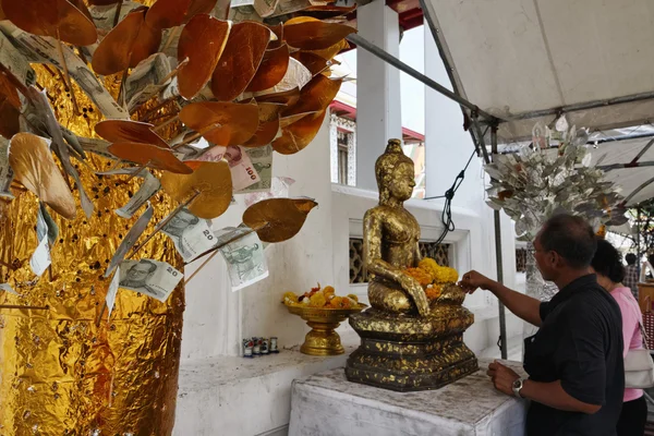 Thailand, bangkok, yai district, arun templet (wat arun ratchawararam), thai par erbjuder blommor till en buddha staty — Stockfoto