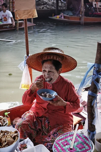 Thailand, bangkok, eine thailändische frau beim essen auf dem schwimmenden markt — Stockfoto