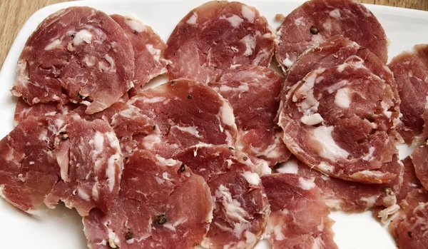 Italienska skivad salami på en maträtt — Stockfoto