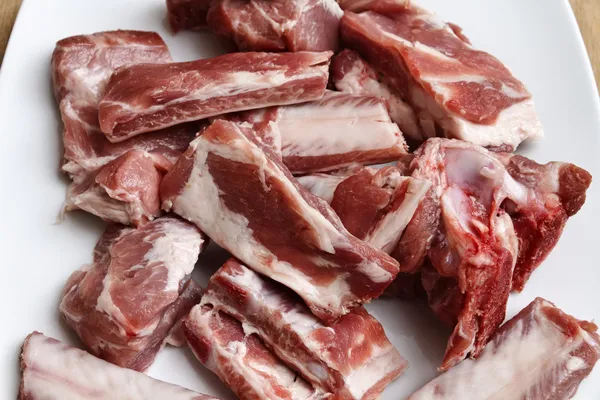 Costelas de porco não cozidas em um prato branco — Fotografia de Stock