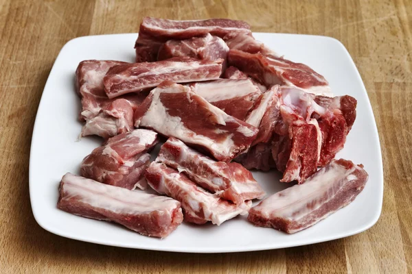 Côtes de porc non cuites sur un plat blanc — Photo