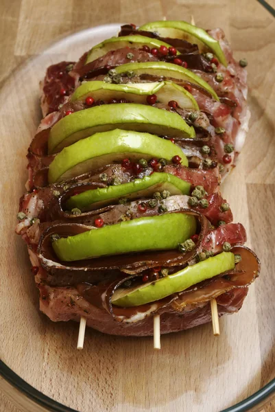 Comida italiana, carne de porco crua (arista) com maçãs fatiadas, bacon e pe verde — Fotografia de Stock