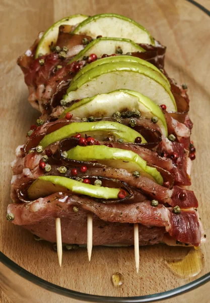 Comida italiana, carne cruda de cerdo (arista) con manzanas en rodajas, tocino y pe verde —  Fotos de Stock