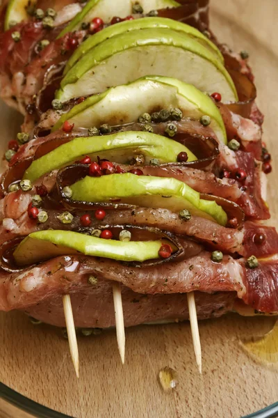Comida italiana, carne de porco crua (arista) com maçãs fatiadas, bacon e pe verde — Fotografia de Stock