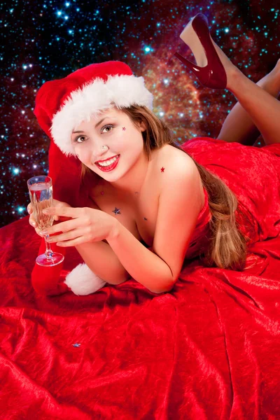 Menina vestindo roupas de Papai Noel com copo de champanhe — Fotografia de Stock