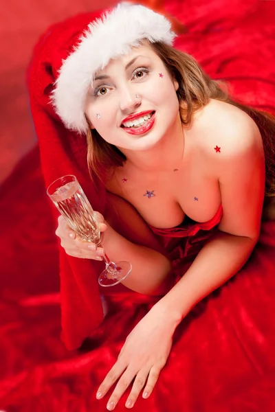 Mädchen trägt Weihnachtsmannkleidung mit Champagnerglas — Stockfoto