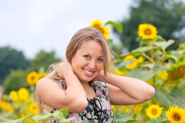 Beautiful woman between sunflowers — Stock Photo, Image