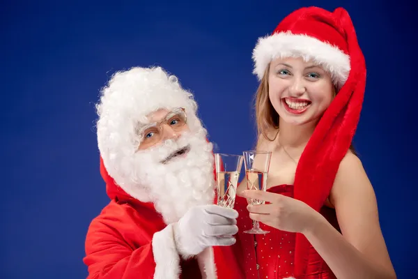 Jultomte med sexig tjej i santa hatt. — Stockfoto