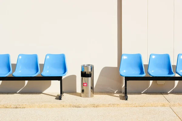 Assentos azuis no chão de cimento — Fotografia de Stock