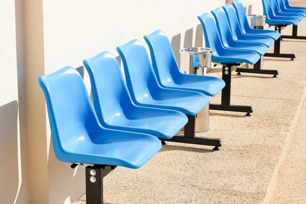 Assentos azuis no chão de cimento — Fotografia de Stock
