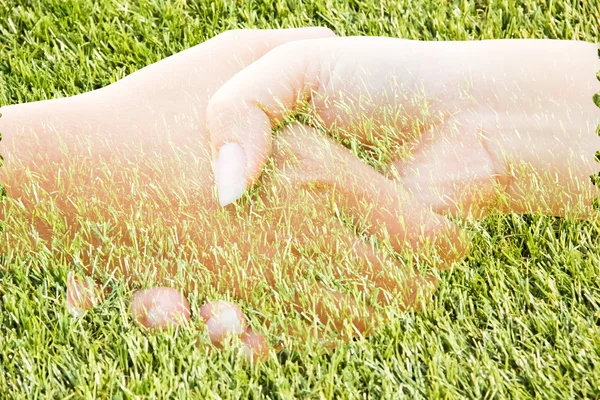Руки на ее фоне как трава — стоковое фото