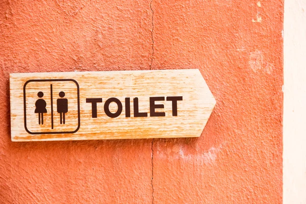 Signs symbol toilet orange on the walls — Stock Photo, Image