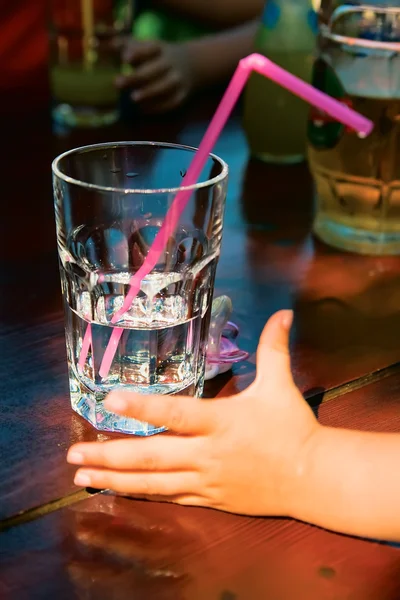 stock image A glass of water and a children's hand