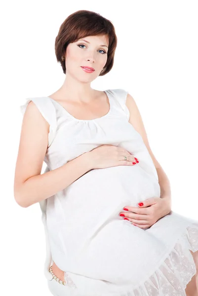 Piękna młoda kobieta w ciąży, obejmując swój brzuch na białym tle o — Zdjęcie stockowe