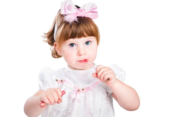 Kleines Mädchen Malerei Make-up Lippenstift isoliert auf weiß — Stockfoto