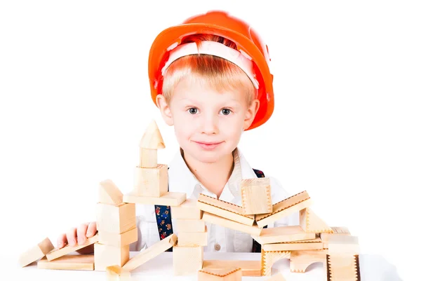 Pequeño niño apila casa de bloques de madera aislados en blanco — Foto de Stock