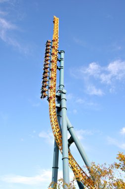 Straigth up roller coaster under blue sky clipart