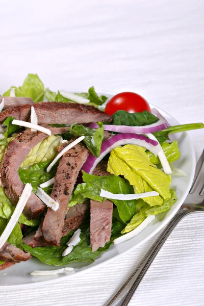 Rundvlees lendenen stroken gemengd met groene salade — Stockfoto