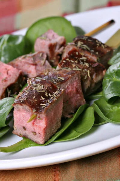 Brochettes de steak de boeuf sur les épinards — Photo
