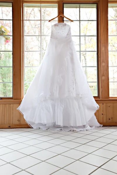 stock image White Wedding Gown Hanging by Window