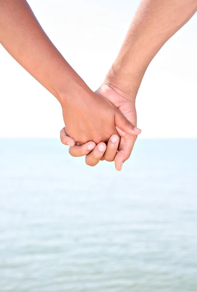 Two Young Holding Hands by Water — Stock Photo, Image