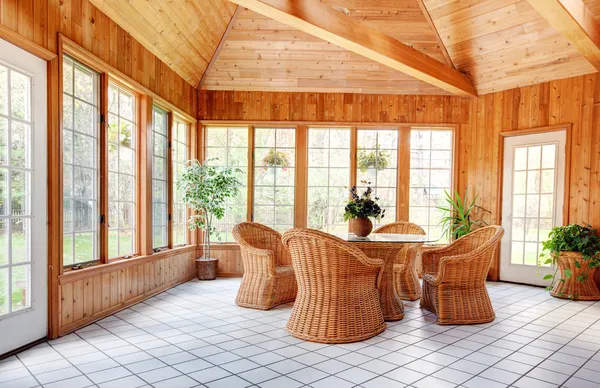 Holzwand Sonnenstube Innenraum mit Korbmöbeln Stockfoto