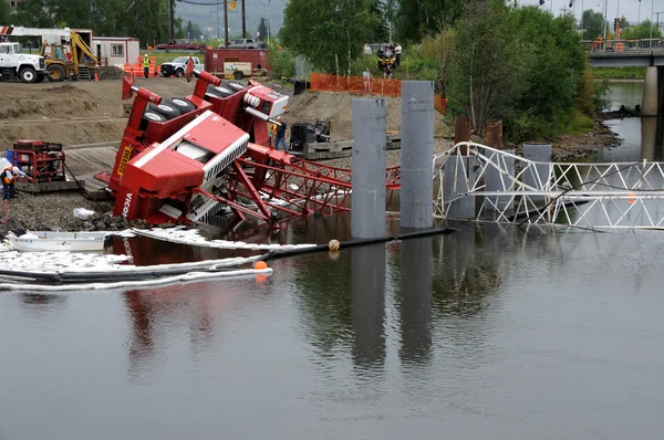 Bridge construction crane stjälper i flod — Stockfoto