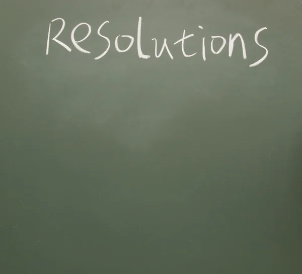 Resolutioner titel skriven med krita på svarta tavlan — Stockfoto