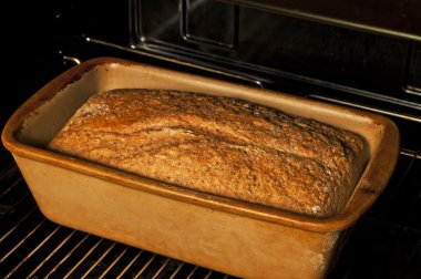 Whole grain bread in an oven clipart