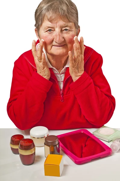 Pensioner with cosmetic products — Stock Photo, Image