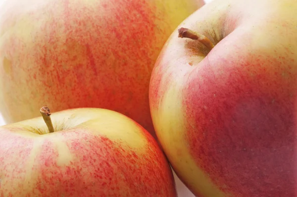 Två apple mot bakgrund av den tredje äpplet. — Stockfoto