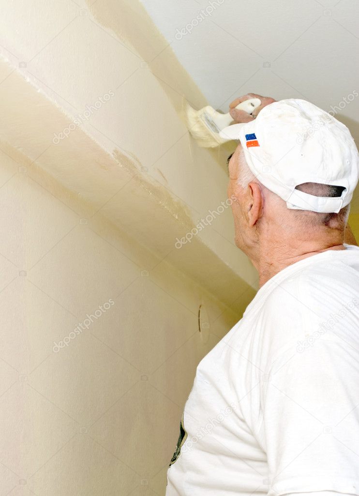 The man paints a withe wall