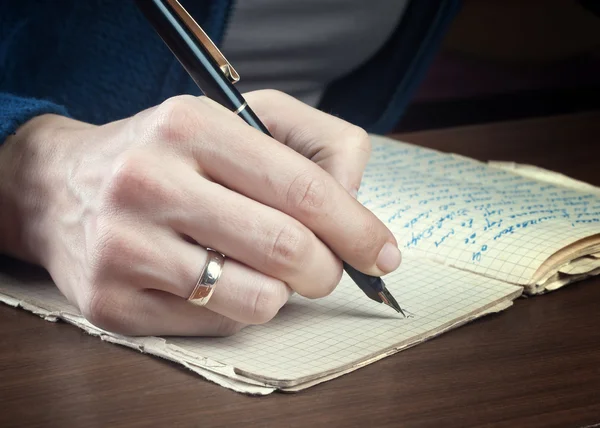 Woman hand writes on a paper — Stock Photo, Image