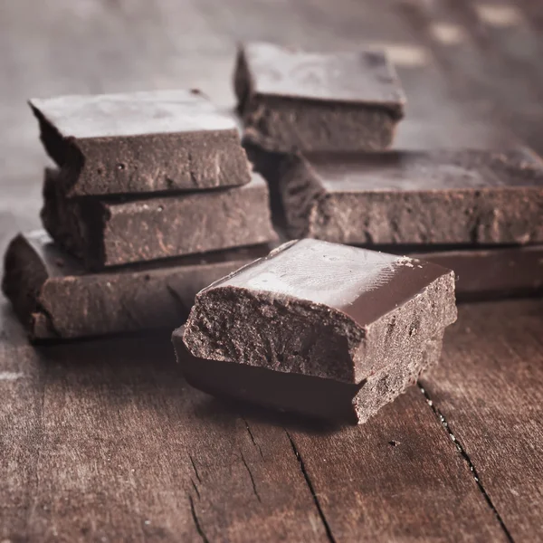 Cioccolato su vecchia tavola di legno — Foto Stock