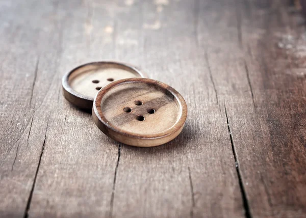Button on a wooden table — Stock Photo, Image