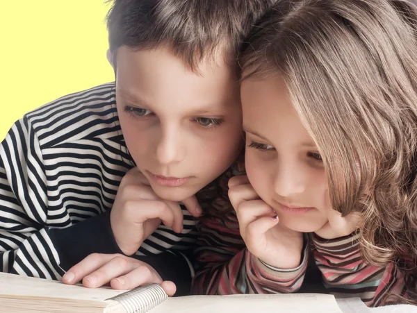 Irmão e irmã lendo um livro, na cama — Fotografia de Stock